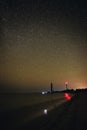Silhouettes of the two Lighthouse sandy beach and ocean against the background of the starry sky Royalty Free Stock Photo