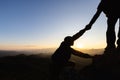 Silhouettes of two people climbing on mountain and helping. Help and assistance concept Royalty Free Stock Photo