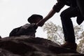 Silhouettes of two people climbing on mountain and helping, Help Royalty Free Stock Photo