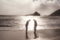 Silhouettes of two people standing barefoot by the ocean, Big Sur coast of California, United States of America aka USA Royalty Free Stock Photo
