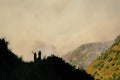 Silhouettes of two people watching mountain side wild fire in Utah