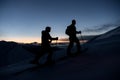 Silhouettes of two skiers with flashlights on their foreheads climbing the mountain slope Royalty Free Stock Photo