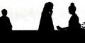 Silhouettes of two teenage girls friends using mobile phones