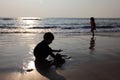 Silhouettes of children play with sand in the Bekal beach