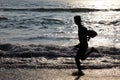 Silhouettes of people play in the waves in the Bekal beach