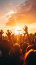 Silhouettes of uplifted hands against a sunset sky with a Christian cross, conveying a sense of communal faith.