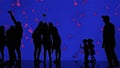 Silhouettes of visitors enjoy looking at jellyfish through the glass in the aquarium