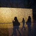 Silhouettes of walking people and trees seen through the broken window