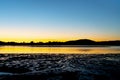 Silhouettes and wet sand patterns at low tide in morning sunrise light Royalty Free Stock Photo