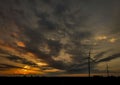 Silhouettes of wind turbines against the dramatic sunset sky Royalty Free Stock Photo