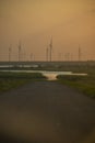 Silhouettes of wind turbines farm Behind the Lake at Sunset.