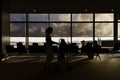 Silhouettes of women with luggage carts in airport departure lounge