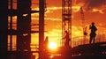 The silhouettes of workers can be seen in every corner of the construction site their movements illuminated by the Royalty Free Stock Photo