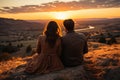 Silhouettes of a young couple admiring beautiful view on sunset. Man and woman looking at scenic evening landscape