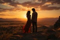 Silhouettes of a young couple admiring beautiful view on sunset. Man and woman looking at scenic evening landscape