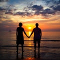 Silhouettes young couple on the beach at sunset