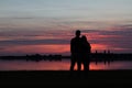 Silhouettes of a young couple at the beach, watching the sunset Royalty Free Stock Photo