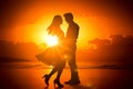 silhouettes of young couple of lovers at sunset on the beach. romance, relationships, love. Holiday romance, honeymoon Royalty Free Stock Photo