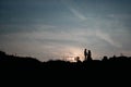 Silhouettes of a young couple lovers at sunset on dramatic sky background. Place for text or advertising Royalty Free Stock Photo