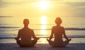 Silhouettes of a young couple sitting in the yoga Lotus position Royalty Free Stock Photo