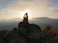 Silhouettes of young couple standing on a mountain and looking to each other on beautiful sunset background. Love of guy Royalty Free Stock Photo