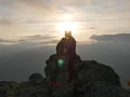 Silhouettes of young couple standing on a mountain and looking to each other on beautiful sunset background. Love of guy Royalty Free Stock Photo