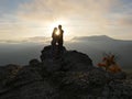 Silhouettes of young couple standing on a mountain and looking to each other on beautiful sunset background. Love of guy Royalty Free Stock Photo