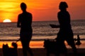 Silhouettes of young couple walking their dogs Royalty Free Stock Photo