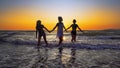 Silhouettes of young group of people jumping in ocean at sunset Royalty Free Stock Photo