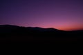 Silhoutte of evening mountains with trees on it and moon on the sky