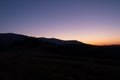 Silhoutte of evening mountains with trees on it and moon on the sky