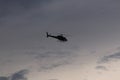 A silhoutte of a helicopter against the evening sky