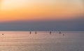 Silhouttes of four stand-up paddler in the sea at sunset Royalty Free Stock Photo