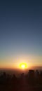 A silhouttes of people watching sunset on the hill