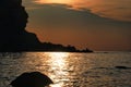 A lonely man sitting on the cliffs at sunset Royalty Free Stock Photo