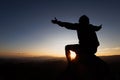 Silhuette Young Woman praying on the mountain, arms outstretched observing a beautiful dramatic sunrise Royalty Free Stock Photo