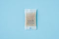 Silica gel or desiccant in paper bag isolated on blue background Royalty Free Stock Photo