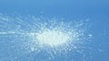 Silicon dioxide powder or Silica nanoparticles falling on blue surface, selective focus. Food additive E551, anti-caking agent.