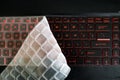 Silicon dust keyboard cover folded and covering half of red glowing back lit keyboard of a gaming laptop Royalty Free Stock Photo