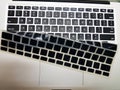 Silicon laptop keyboard cover raised to show underlying laptop isolated keys
