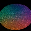 Silicon wafer with intricate circuit patterns, reflecting a spectrum of colors. The Royalty Free Stock Photo