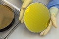 Silicon Wafers in steel holder box take out by hand in gloves- A wafer is a thin slice of semiconductor material, such