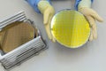 Silicon Wafers in steel holder box take out by hand in gloves- A wafer is a thin slice of semiconductor material, such