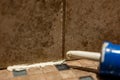 Silicone caulk being applied along a tile joint in a bathroom shower.