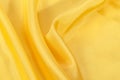 Silk background, texture of yellow shiny fabric