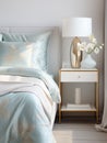 Silk bedding on a bed with a nightstand and lamp, delicate interior in the style of light gold and light azure Royalty Free Stock Photo