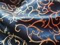 Silk blue fabric with golden curls. Textiles for upholstery, curtains and festive clothing. The fabric is softly folded in waves