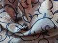 Silk blue fabric with golden curls. Textiles for upholstery, curtains and festive clothing. The fabric is softly folded in waves