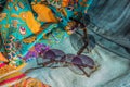 Silk clothes abstract texture and hippie sun glasses Royalty Free Stock Photo