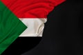 Silk national flag of Sudan state folded onto black blank form, concept of tourism, economy, politics, emigration